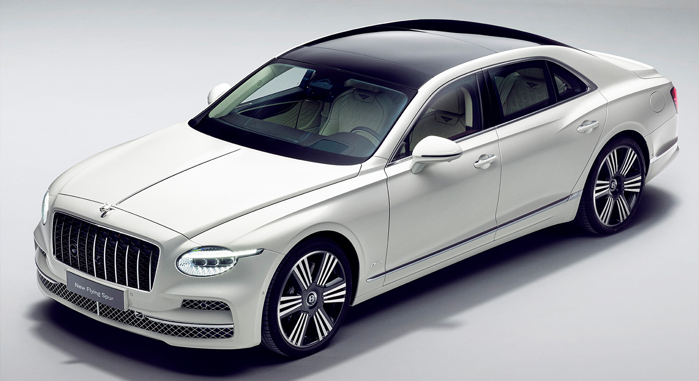 Elegant white luxury sedan with a sleek design and glossy black roof. Features include chrome detailing and distinctive alloy wheels, exuding sophistication.